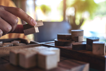 Closeup image of people playing and building round wooden puzzle game