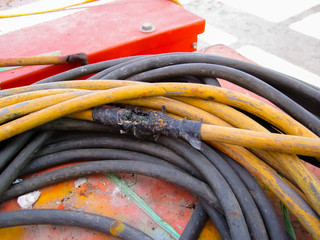 The old and damaged  electrical line, Close up view of damaged, repair by black tape.