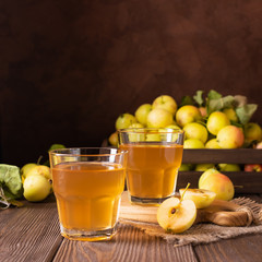 Apple drink juice or cider in a transparent glass on a dark wooden background. Home Sangria. Autumn concept. Front view. Horizontal frame. Copy space.