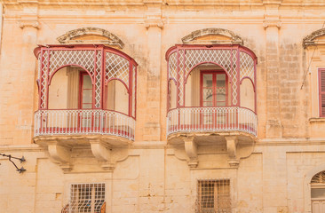 Fototapeta na wymiar Mdina, Malta. Fragment of the facade with decorative balconies
