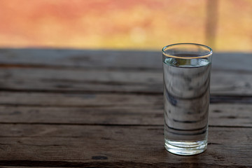 glass of water on a wooden table in the morning