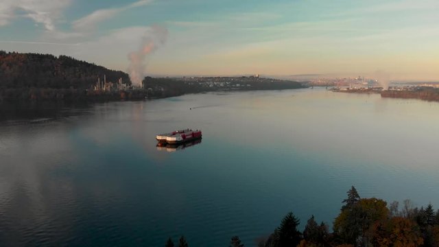 An aerial shot of a barge in Burrard Inlet with the Parkland oil refinery and downtown Vancouver in the background.