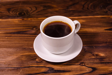 Cup of dark coffee on wooden table