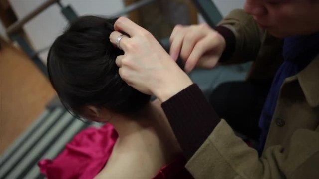 High angel of hair stylist pinning black hair into a bun