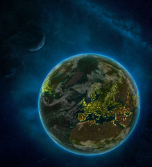 Netherlands from space on Earth at night surrounded by space with Moon and Milky Way. Detailed planet with city lights and clouds.