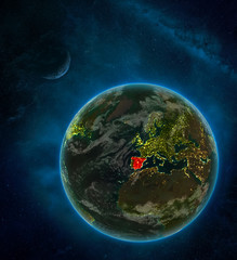 Spain from space on Earth at night surrounded by space with Moon and Milky Way. Detailed planet with city lights and clouds.