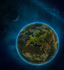 Greece from space on Earth at night surrounded by space with Moon and Milky Way. Detailed planet with city lights and clouds.