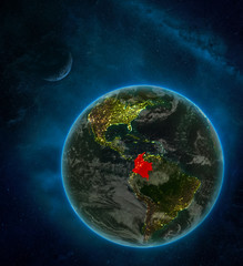 Colombia from space on Earth at night surrounded by space with Moon and Milky Way. Detailed planet with city lights and clouds.