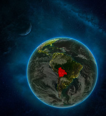 Bolivia from space on Earth at night surrounded by space with Moon and Milky Way. Detailed planet with city lights and clouds.