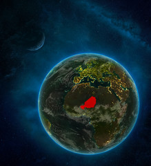 Niger from space on Earth at night surrounded by space with Moon and Milky Way. Detailed planet with city lights and clouds.