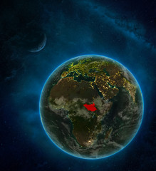 South Sudan from space on Earth at night surrounded by space with Moon and Milky Way. Detailed planet with city lights and clouds.