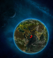 Oman from space on Earth at night surrounded by space with Moon and Milky Way. Detailed planet with city lights and clouds.