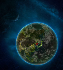 North Korea from space on Earth at night surrounded by space with Moon and Milky Way. Detailed planet with city lights and clouds.