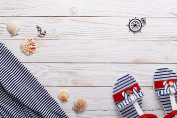Travel vacation concept with sandals, seashells and striped t-shirt. Top view with copy space