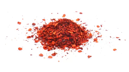 Fotobehang pile crushed red cayenne pepper, dried chili flakes and seeds on white background. © RATMANANT