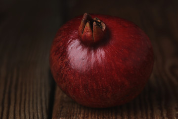 Beautiful composition with juicy pomegranates, on old wooden table