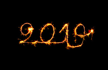 New Year 2019 text handmade written sparklers fireworks. Beautiful Shiny Golden numbers 2019 isolated on black background for design