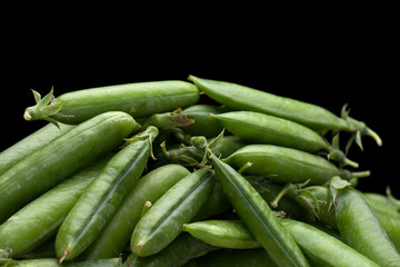 green fresh peas isolated on black background