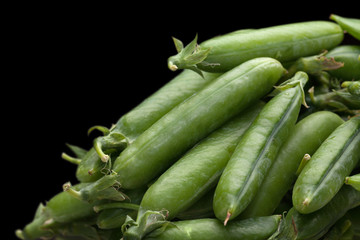 green fresh peas isolated on black background