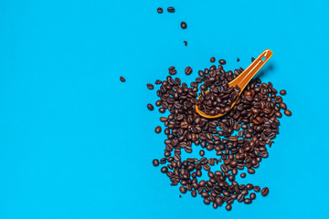 Coffee beans spilled on a bright blue background