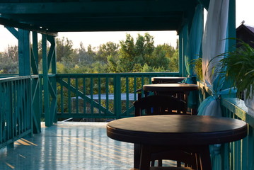 Blurred abstract background of outdoor cafe or restaurant . Outdoor cafe with tables, chairs and barrel outside at the old town.