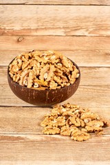 Peeled walnuts in the brown bowl on wooden table with copy space, close-up