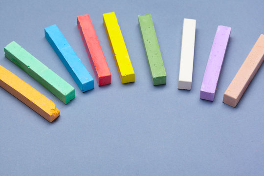 pile of multi color chalk on blue background