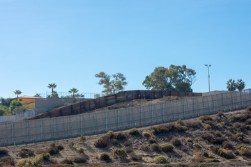 Double-layered secured border wall between the United States and Mexico visible on sunny day from Border Field State Park in California 