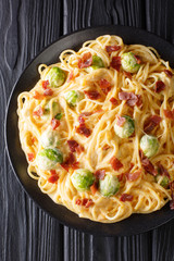 Cheesy Spaghetti, bacon, and Brussels sprouts covered in melting cheese closeup. Vertical top view