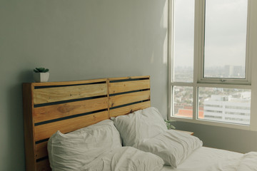 Loft wooden pine headboard with white bed.