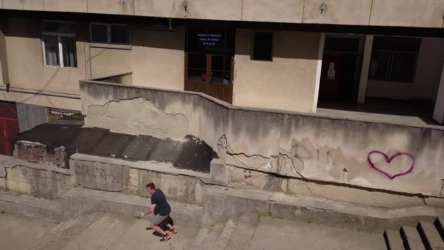 Tracking Shot of a Young Adult Male Thrill Seeker Jumping Off a Balcony then Doing a Backflip.