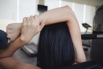 Woman stretching her arms in the fitness gym.