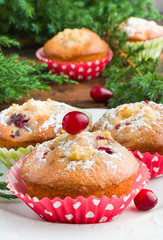 Cranberry muffins with ricotta on white plate on wooden table with Christmas decoration
