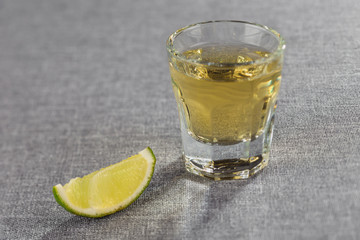 Closeup shot of gold tequila with lime slice. Diagonal sharpness.