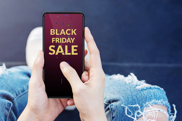 Black Friday with Sale Promotional Concept. Shopping Lifestyle. Young Hipster Girl using SmartPhone to get Deals, top view