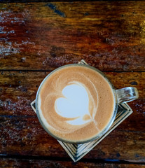 Hot latte in glass on wood table