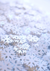 White artificial snowflakes on soft background. Winter background. Decorative template for cards, banners, posters.