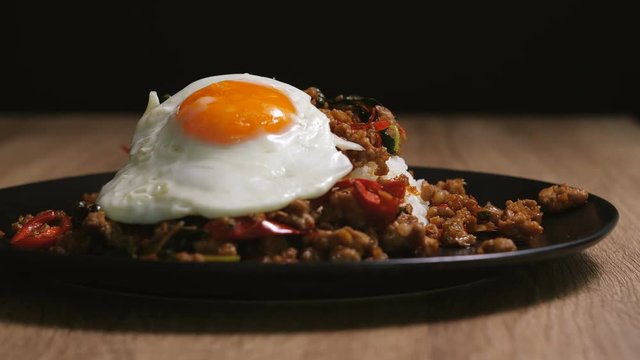 lay down egg fried on spicy stir fried chopped pork with hot basil , Spicy Thai cuisine food , 4k resolution