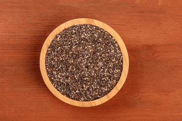 An overhead photo of chia seeds, shot from the top on a dark rustic background with a place for text