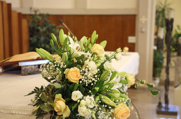 flowers with roses and daffodils on top of the church altar duri