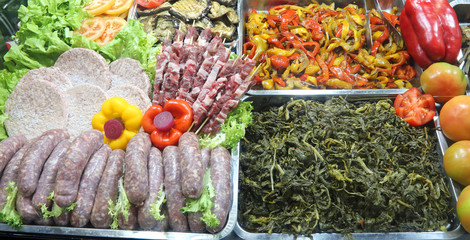 food at the cafeteria with many sausages spinach peppers skewers