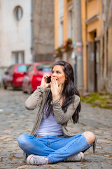 Fototapeta premium Cute young woman using cellphone in urban surroundings.