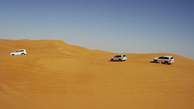 Aerial Dubai Drone view of Desert vehicles dune bashing 