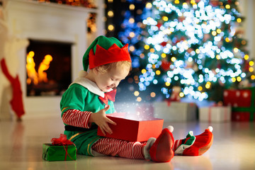Kids at Christmas tree. Children open presents