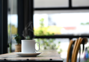 Coffee with smoke on wooden table.