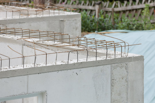 Baustellendetails mit frisch gegossenen Betonw&auml;nden und Armierungseisen