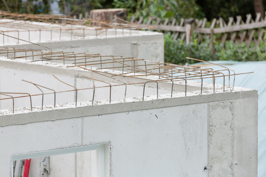 Baustellendetails mit frisch gegossenen Betonw&auml;nden und Armierungseisen