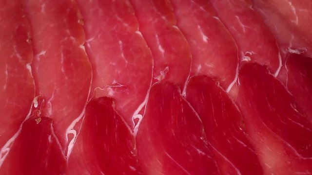 Pork ham red meat slices texture pattern on rotating plate food hd video looping clip