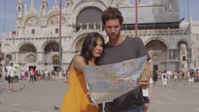 Pareja enamorada mira un mapa en Venecia