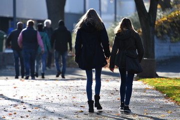 Two joung girls walking in an autumnal park in Hannover-Germany.